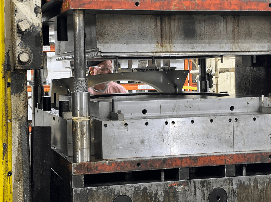 US Machine and Tool machinist using a metal stamping machine.